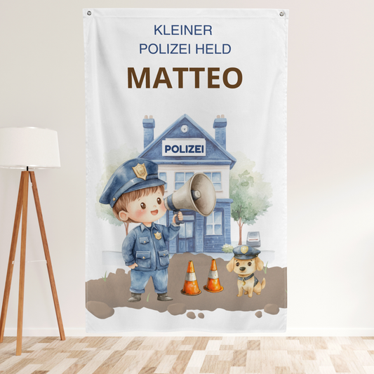 Nahaufnahme der Personalisierung „MATTEO“ und eines kleinen Polizisten mit Megafon auf dem Textil-Wandbanner