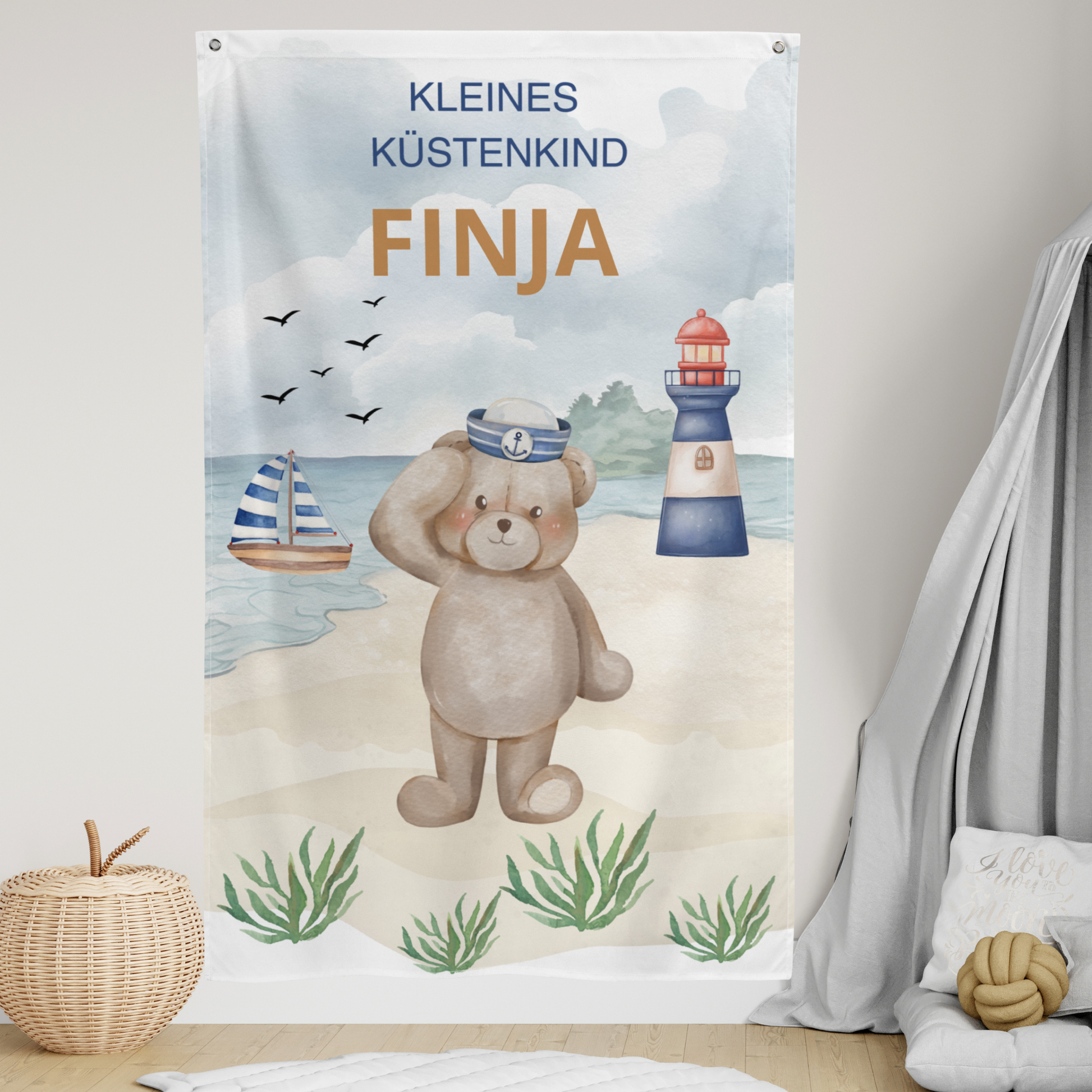 Nahaufnahme des personalisierten Namens „FINJA“ und des süßen Bären im Matrosen-Look auf dem Textil-Wandbanner.